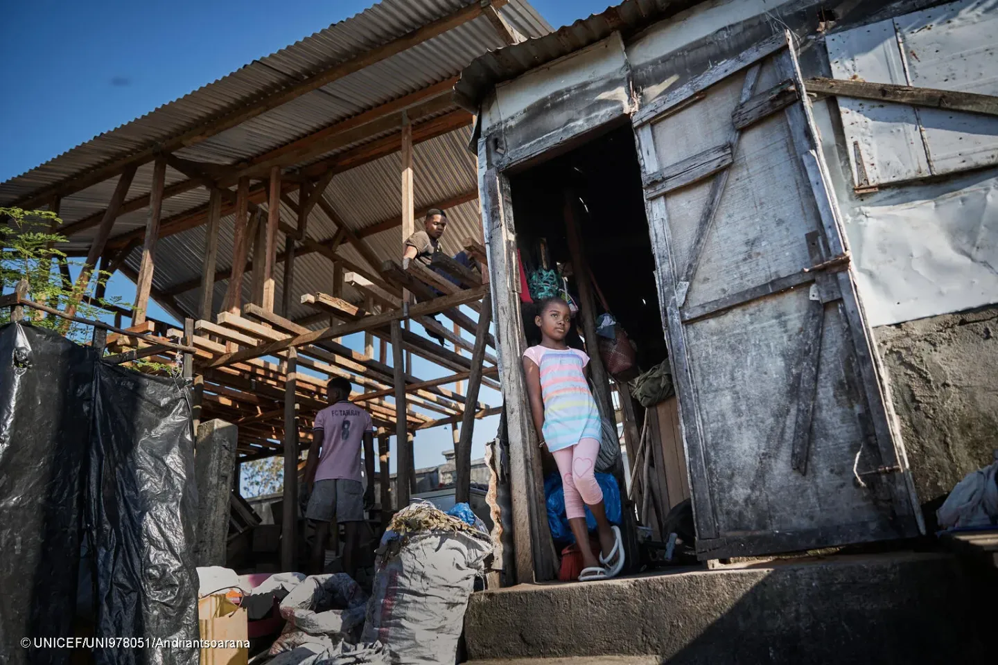 Aur&eacute;lie, 11 ans, se tient &agrave; l&rsquo;entr&eacute;e de cuisine. &Agrave; c&ocirc;t&eacute; d&rsquo;elle, la structure en bois de leur maison est en cours de reconstruction.