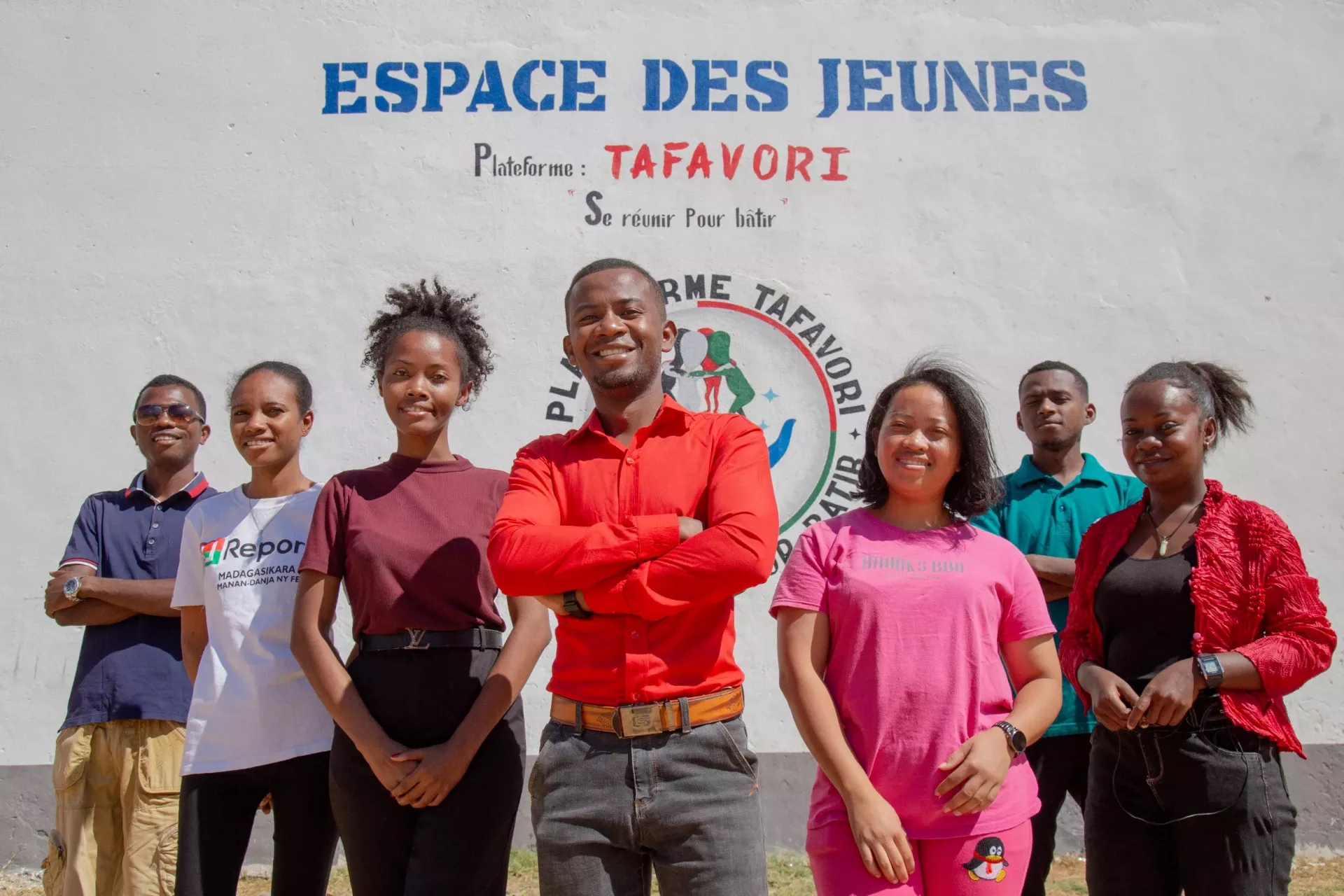 Djumady (au centre), pr&eacute;sident de la plateforme Tafavori, entour&eacute; par quelques membres, devant la fresque murale de l&rsquo;espace des jeunes.