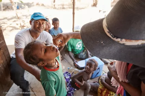 Village d’Ankazomborona, région de Boeny au nord-ouest de Madagascar - Une enfant recevant le vaccin contre la polio pendant le troisième passage de la campagne de 2023, sous l’assistance de Kenny Rogers, spécialiste de la chaîne de froid des vaccins à l’UNICEF.