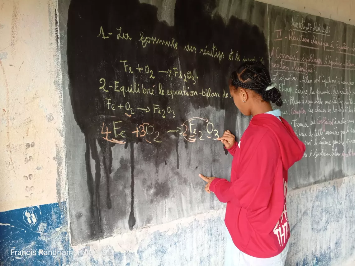 Jarelle correcting a physics and chemistry exercise on the blackboard.