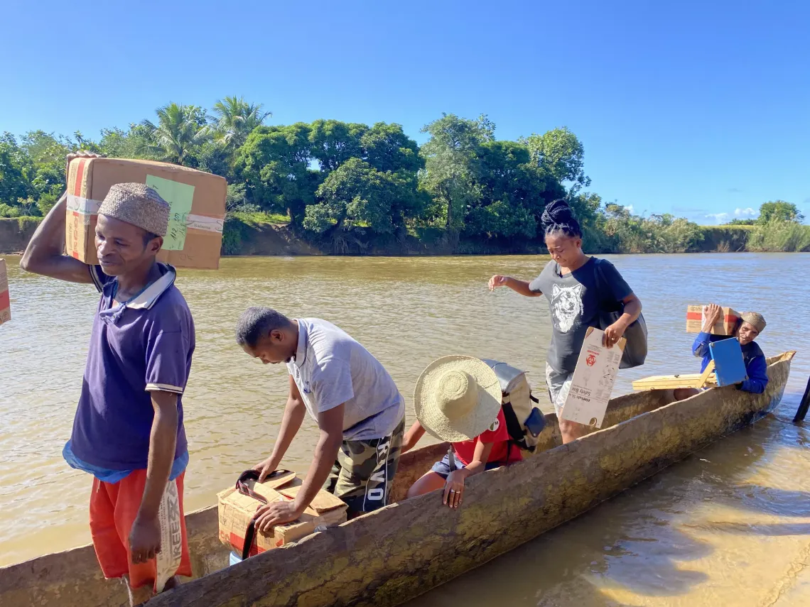 The team boards a boat to cross the Menagnivo river
