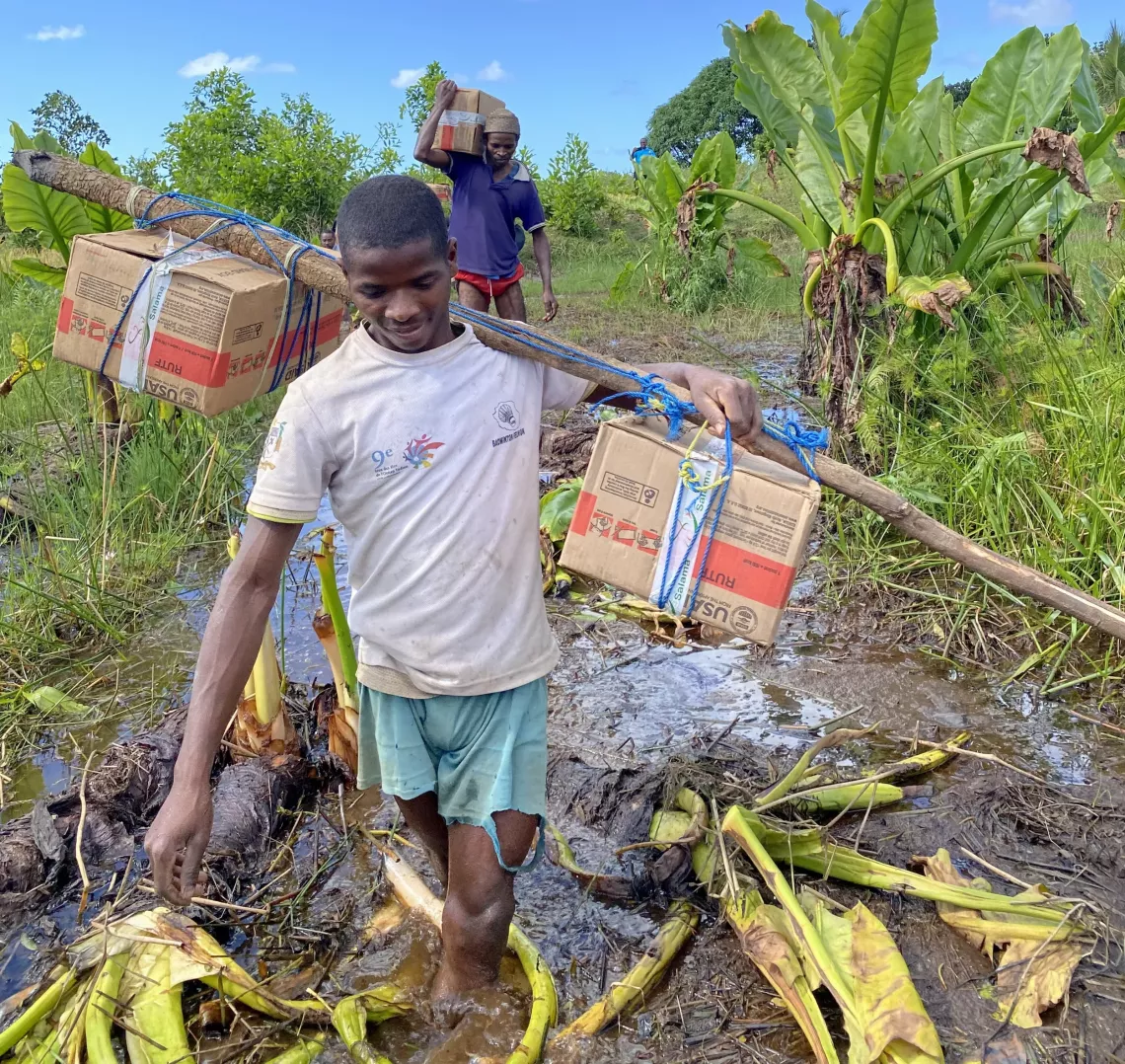 The community members carry boxes of the therapeutic food known as PlumpyNut as it resembles peanut butter. 