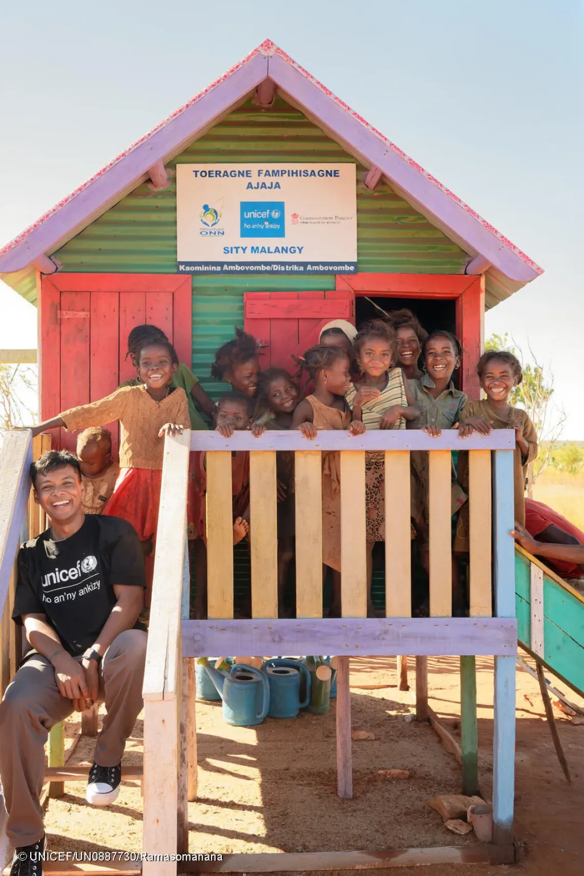 Le site communautaire de Malangy, financ&eacute; par Monaco, KfW et le Comit&eacute; danois pour l'UNICEF, comprend une aire de jeux qui accueille des groupes d'enfants de 6 &agrave; 36 mois toutes les deux semaines.  Mirado, ambassadeur de l'UNICEF &agrave; Madagascar, pose avec les enfants au chalet du site.