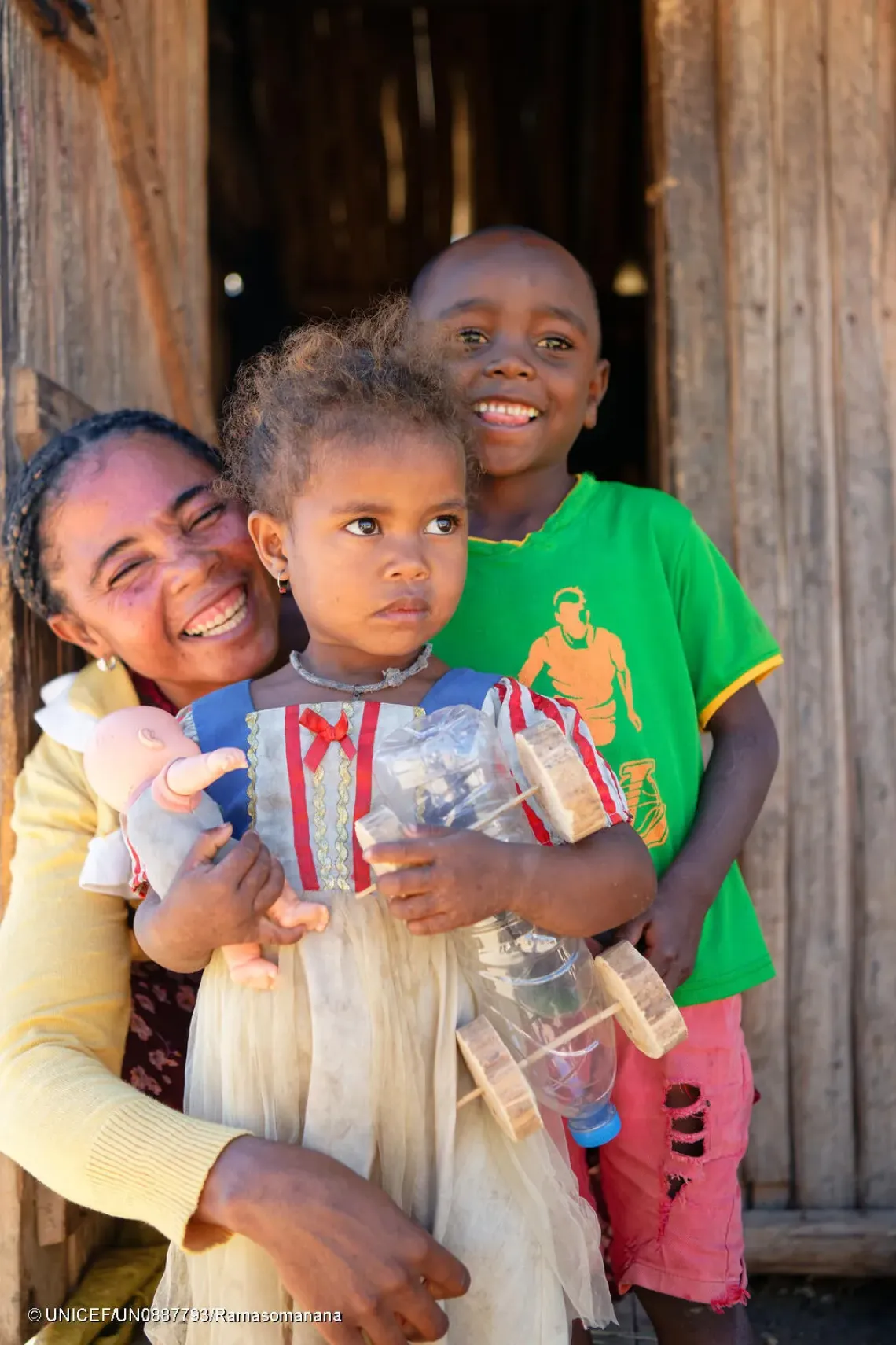 Nasolo Miza et ses deux enfants Tsodranoe, 2 ans et  Rodrigue, 4 ans se tiennent devant leur maison.