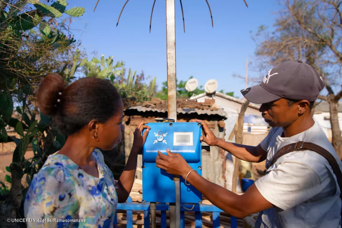 Mbola et Vololoniaina actionnent l&rsquo;appareil pour distribuer l&rsquo;eau. 