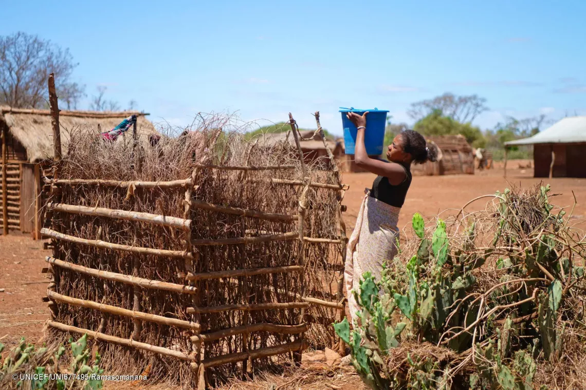 October 17, 2024 - Koronga Centre, Commune of Ambatotsivala, Beloha District, Androy Region, Madagascar : Haingotiana, 15, in Grade 4 in Ikorongo Primary Public School, Haingotiana, 15, in Grade 4 in Ikorongo Primary Public School, carrying a bucket of water in front of her shower. 