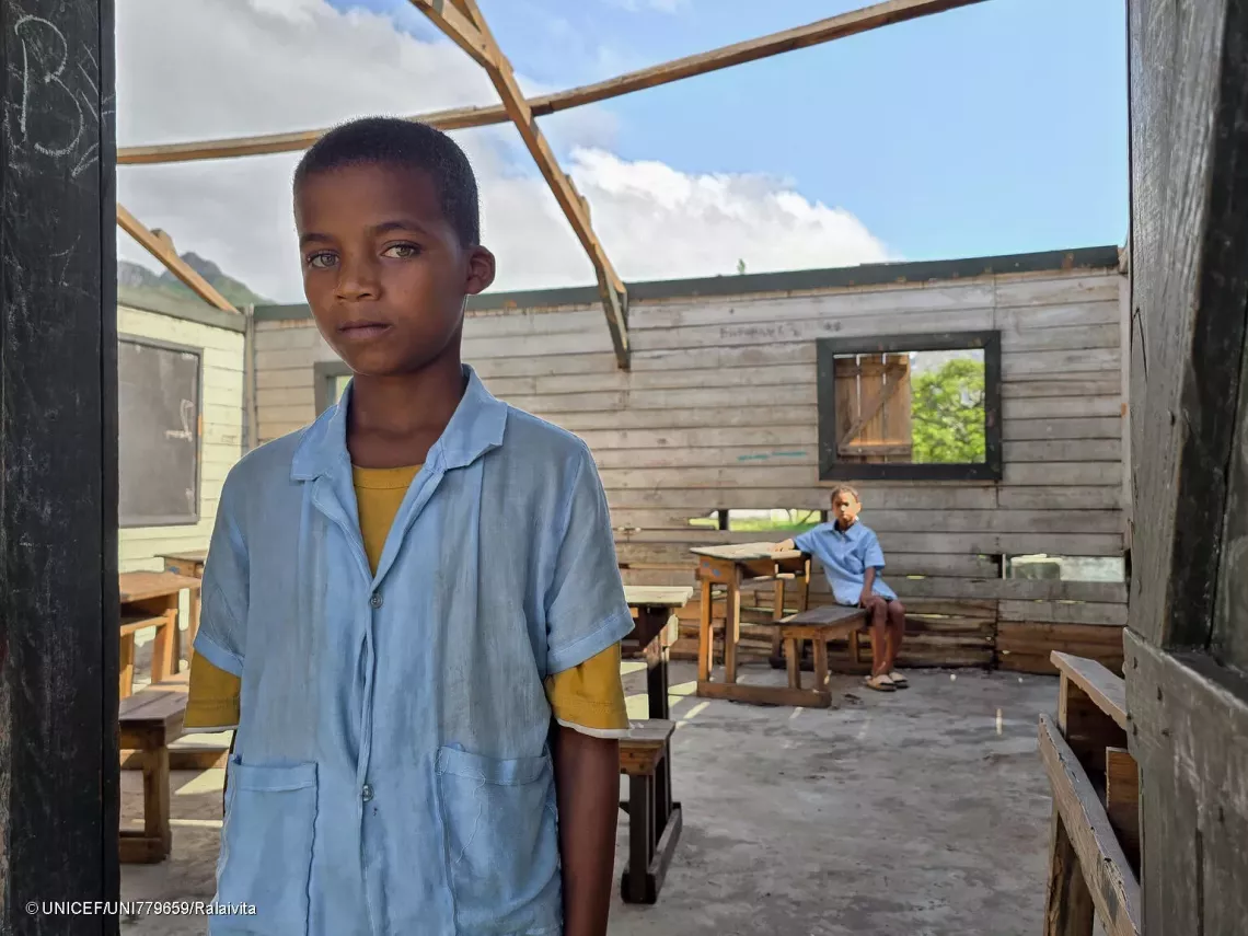 Portrait of Edvin with Christianah in the background, in the classroom without a roof.