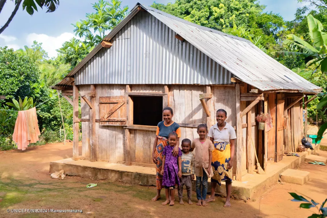 Portrait of Lucie and her four children in front of their home.