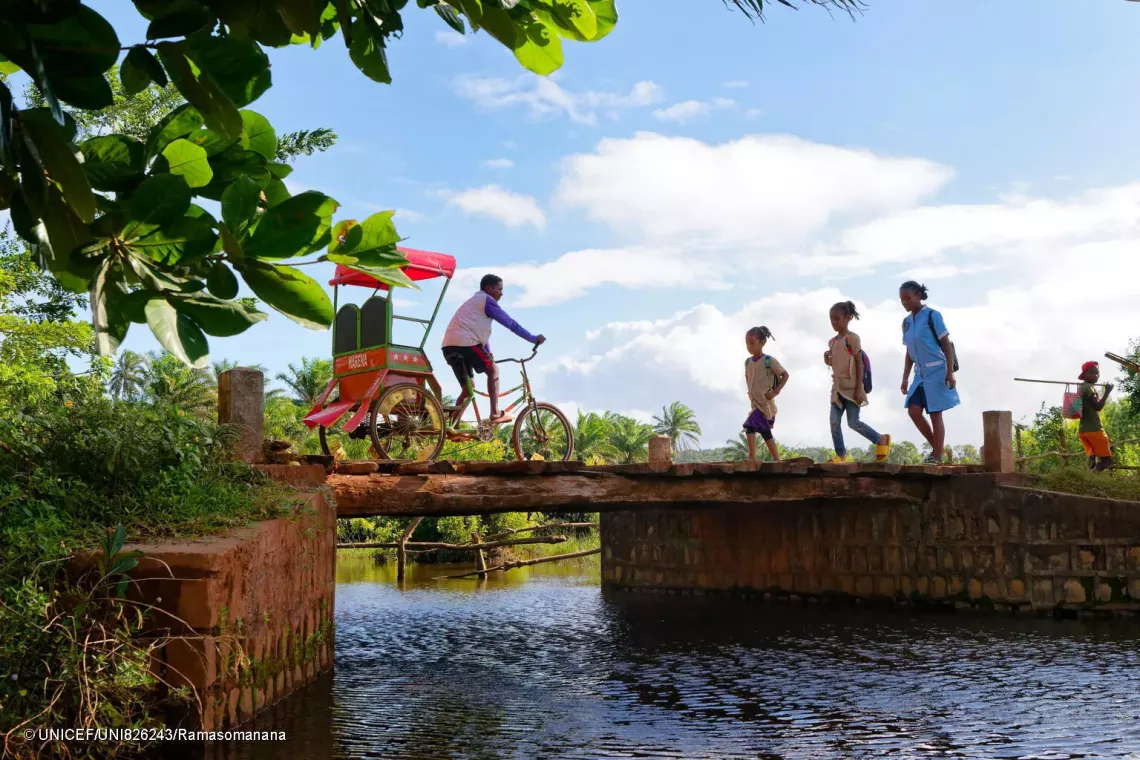 The three sisters crossing a bridge on their way to school.