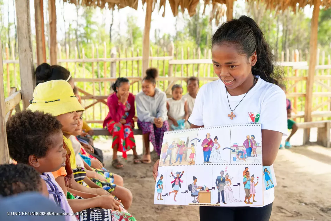Ando, 23, leads a listening group session on the fight against child marriage.