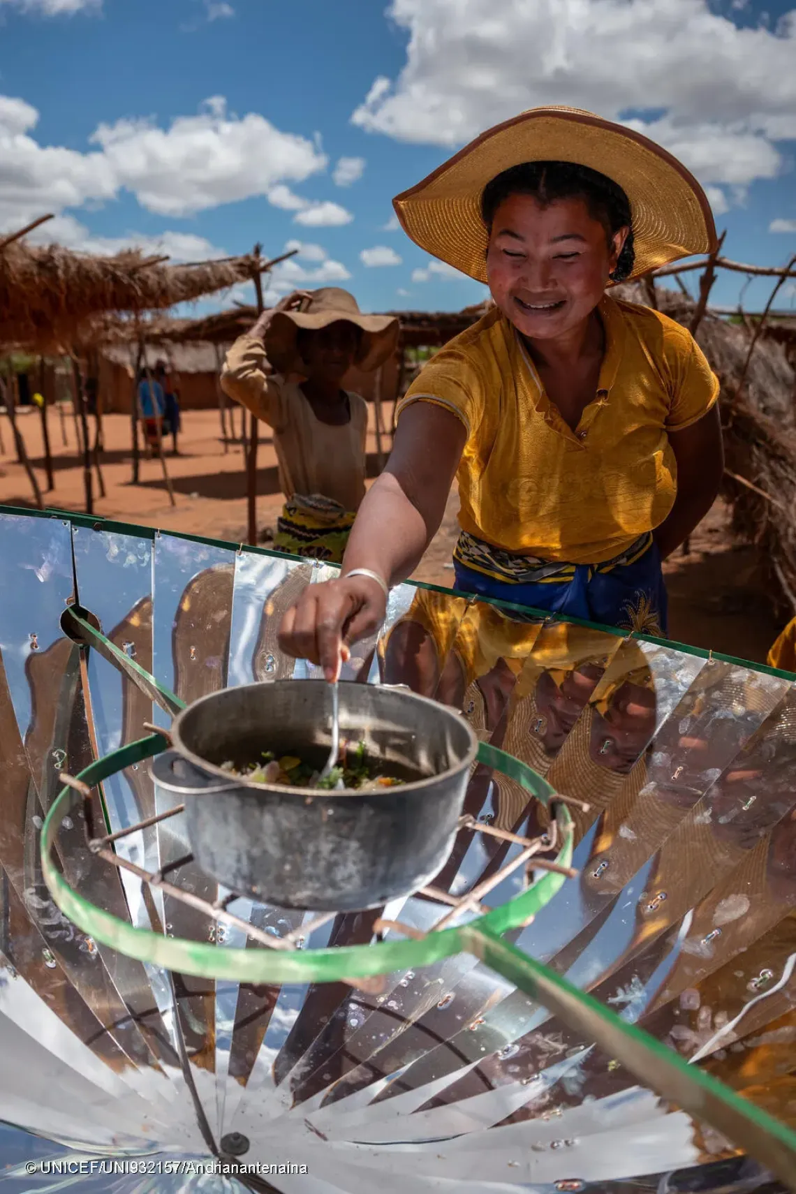 L&rsquo;une des habitantes v&eacute;rifie la cuisson des l&eacute;gumes, pr&eacute;par&eacute;s sp&eacute;cialement pour une d&eacute;monstration avec le foyer solaire. 