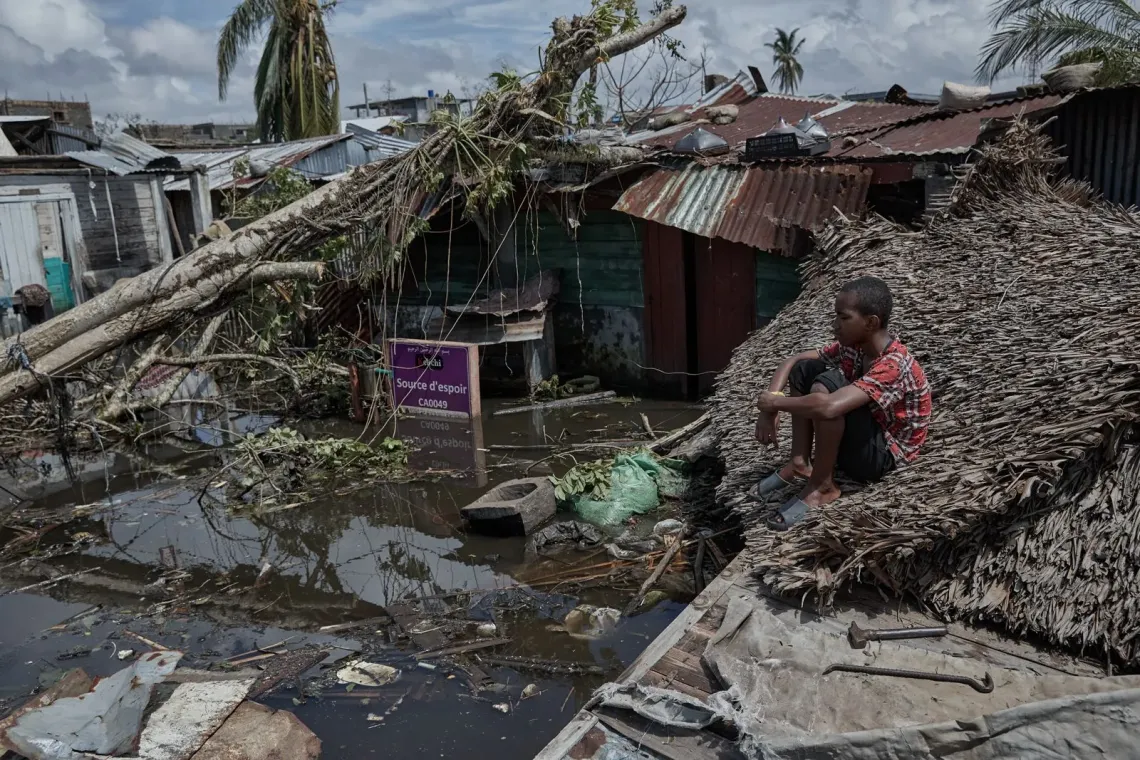 Jacqueline, standing in dirty water, in her house flooded by rising waters after Cyclone Gezani struck.