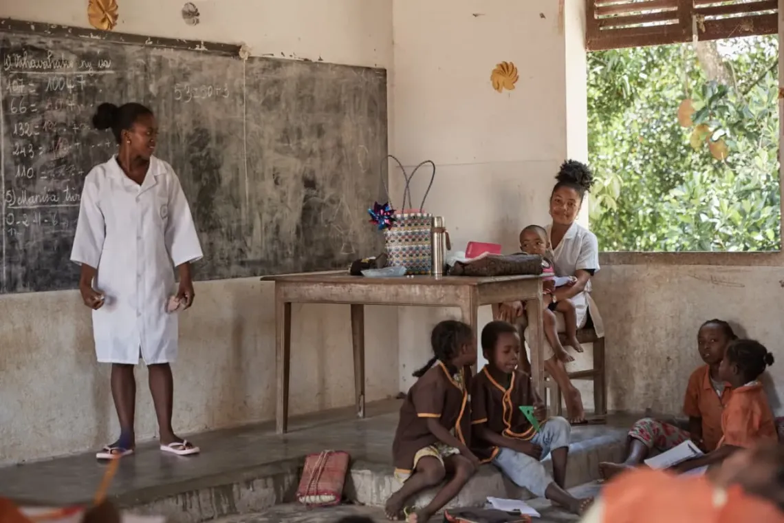 Zafrine avec son fils Wendjino dans la salle de classe en train d&rsquo;enseigner ses &eacute;l&egrave;ves de la classe de10&egrave;me de l&rsquo;&eacute;cole primaire publique de Mahambo.