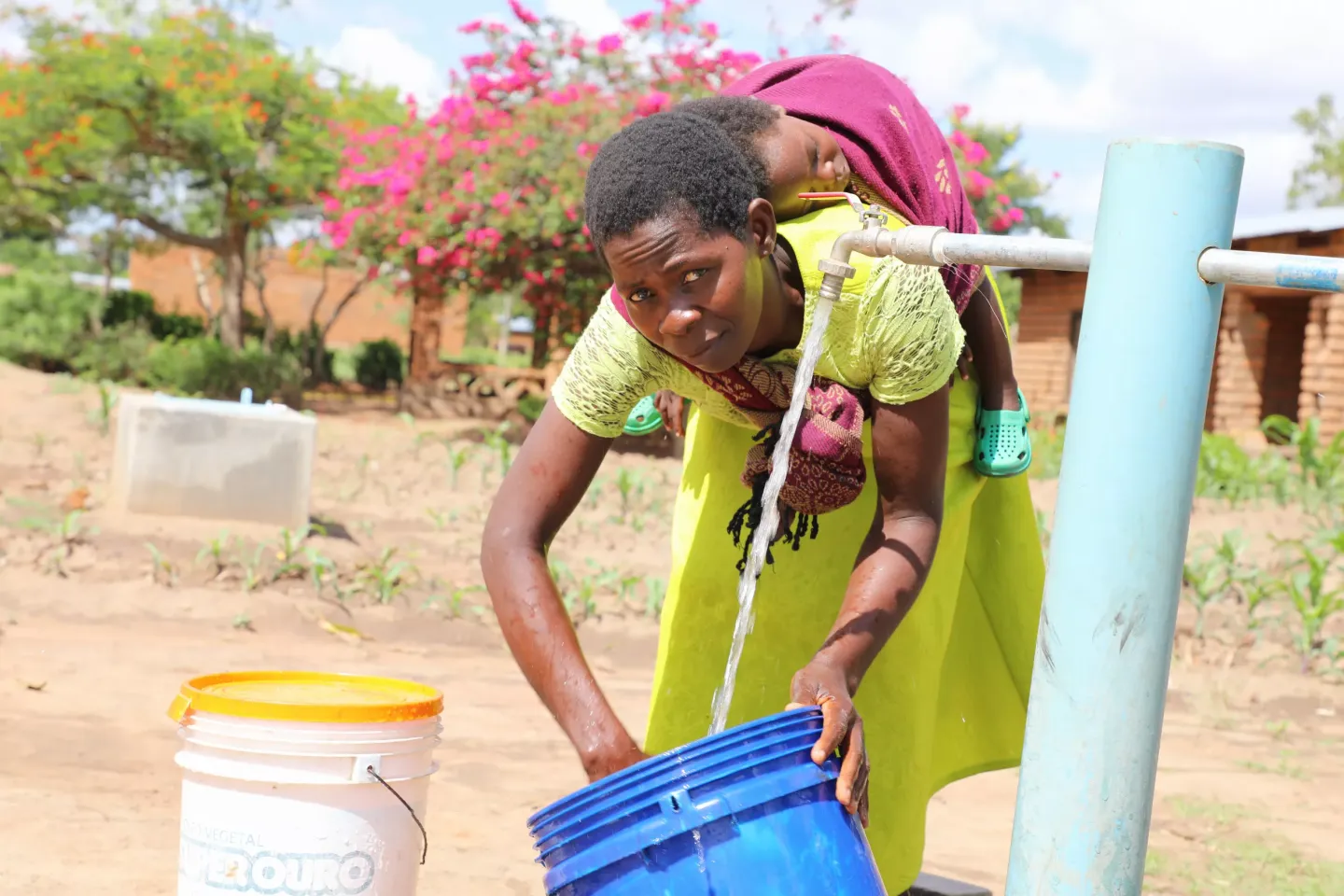 Melise Madeya, from Mchelera village, southern Malawi, fetching water at one of the water points