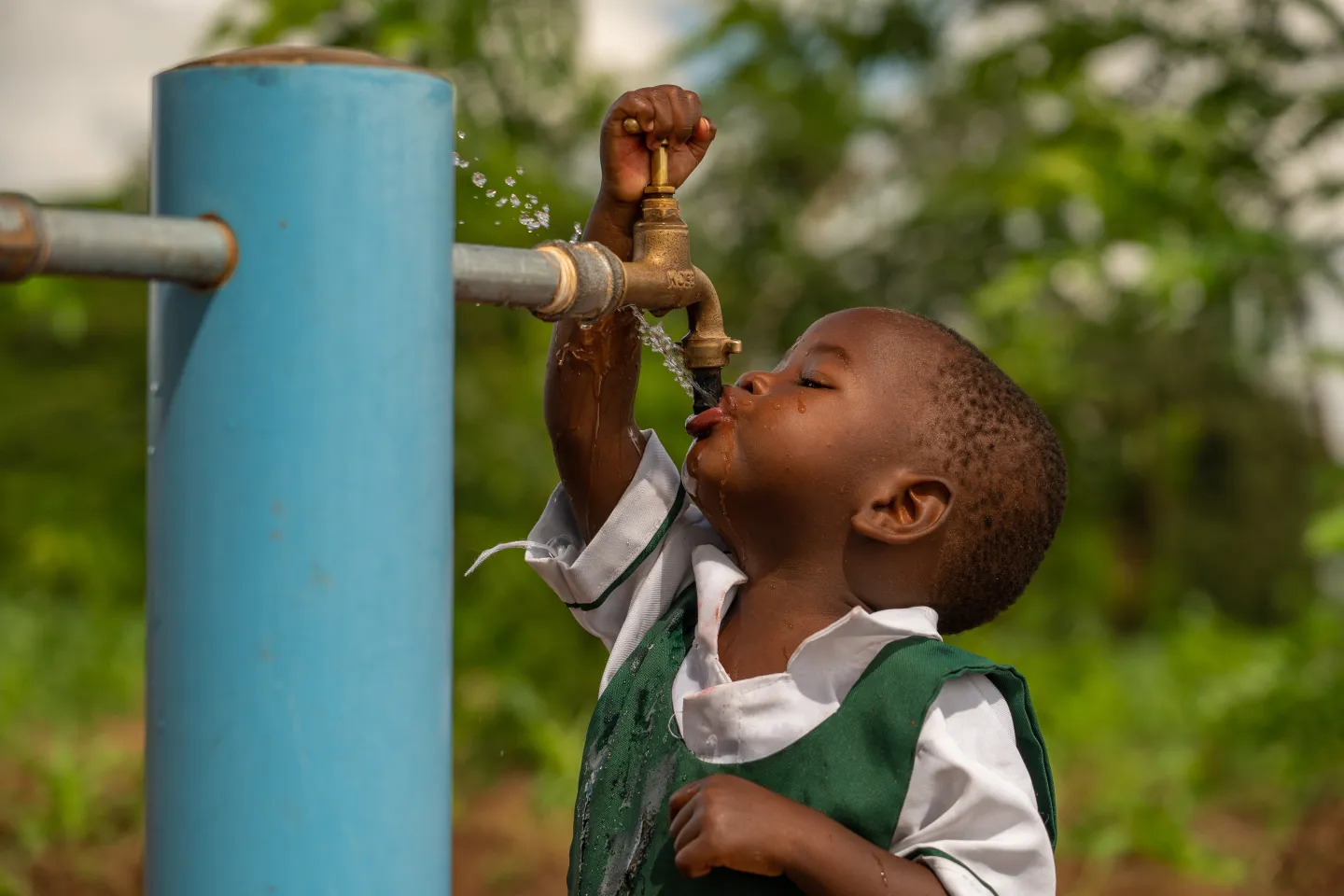 A nursery school learner, Tracy Mayamiko, 2, drinks water from a new UNICEF-supported solar-powered water system in Kusichi village in Lilongwe