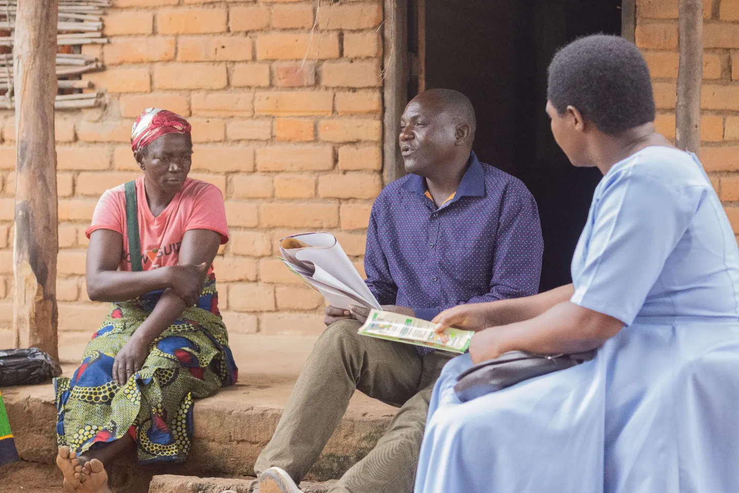  Masauko Msukwa and Ivy Kumwenda engaging in a discussion with Emily Kalilawaleke, a community member, on how to prevent cholera in Mvina Village, T/A Mwankhunikira, Rumphi District.