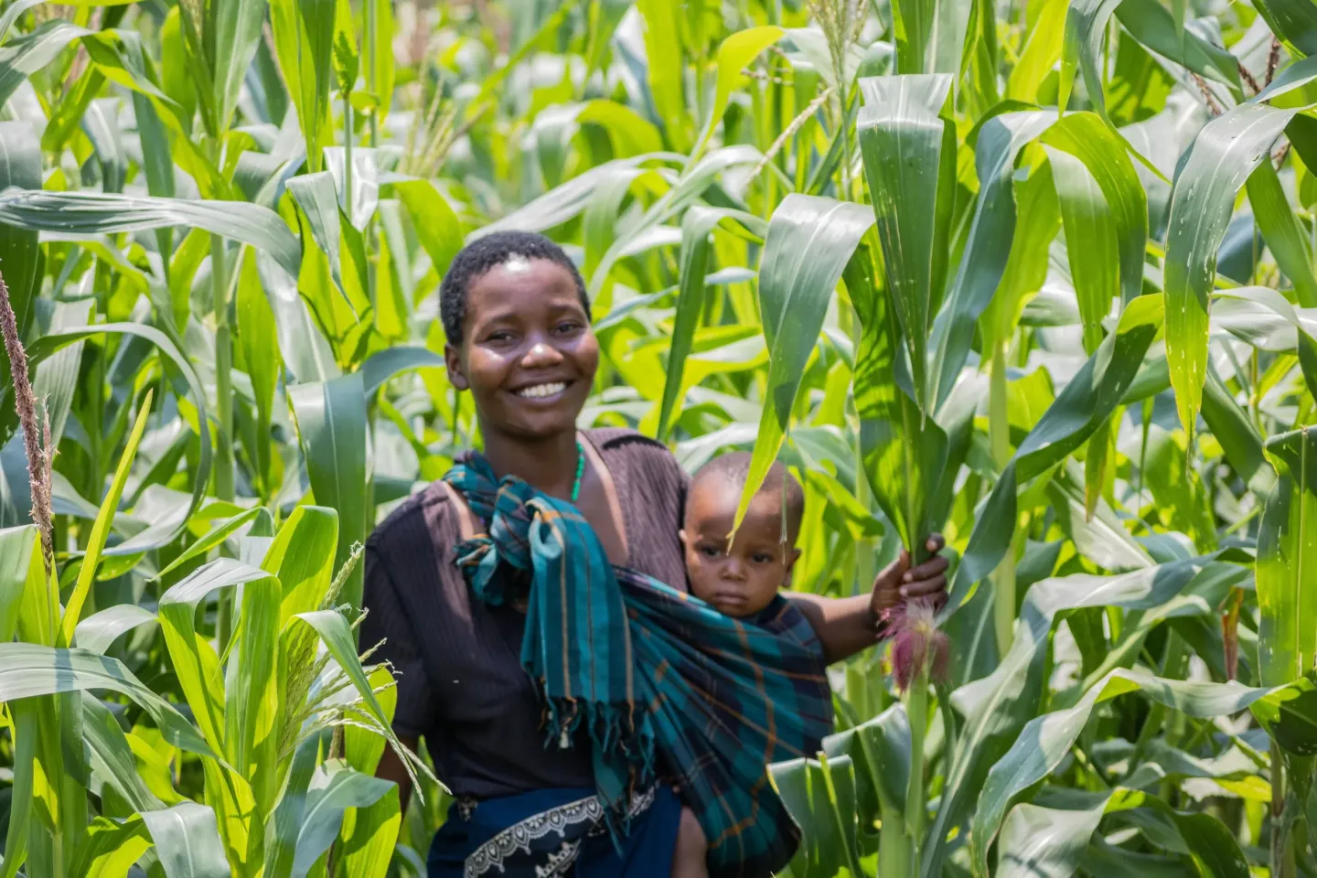 Doreen Thomas and her child tend to crops at their home in TA Kambwiri, Salima, supporting access to diverse foods.