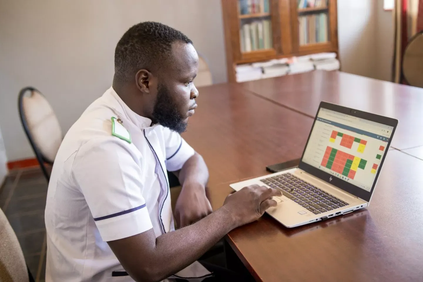 Allan Chilima, RMNCAH scorecard Facilitator at Kasungu District Hospital,  reviewing Kasungu district's data on the scorecard