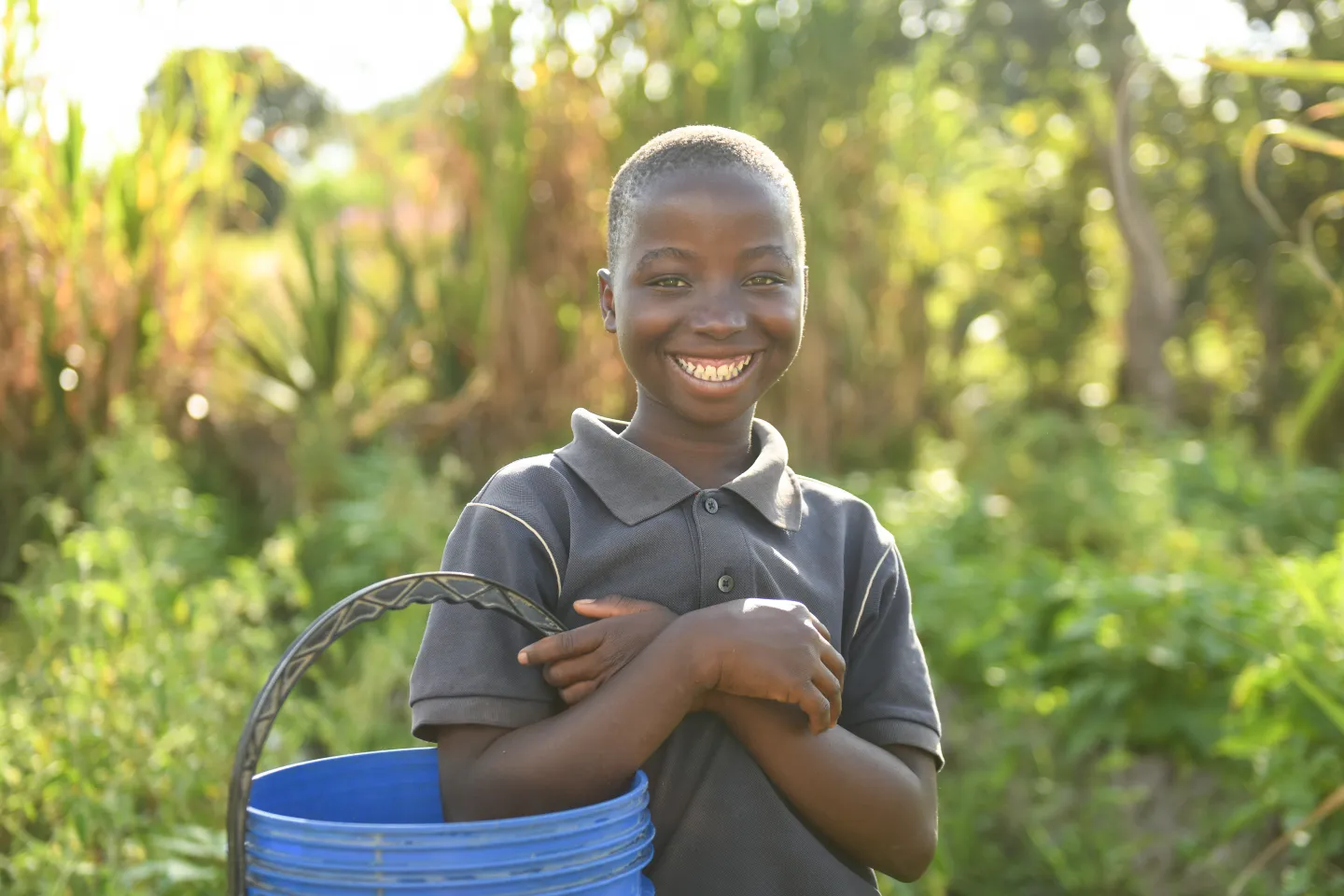 A child holds a bucket of water in a village in Lilongwe
