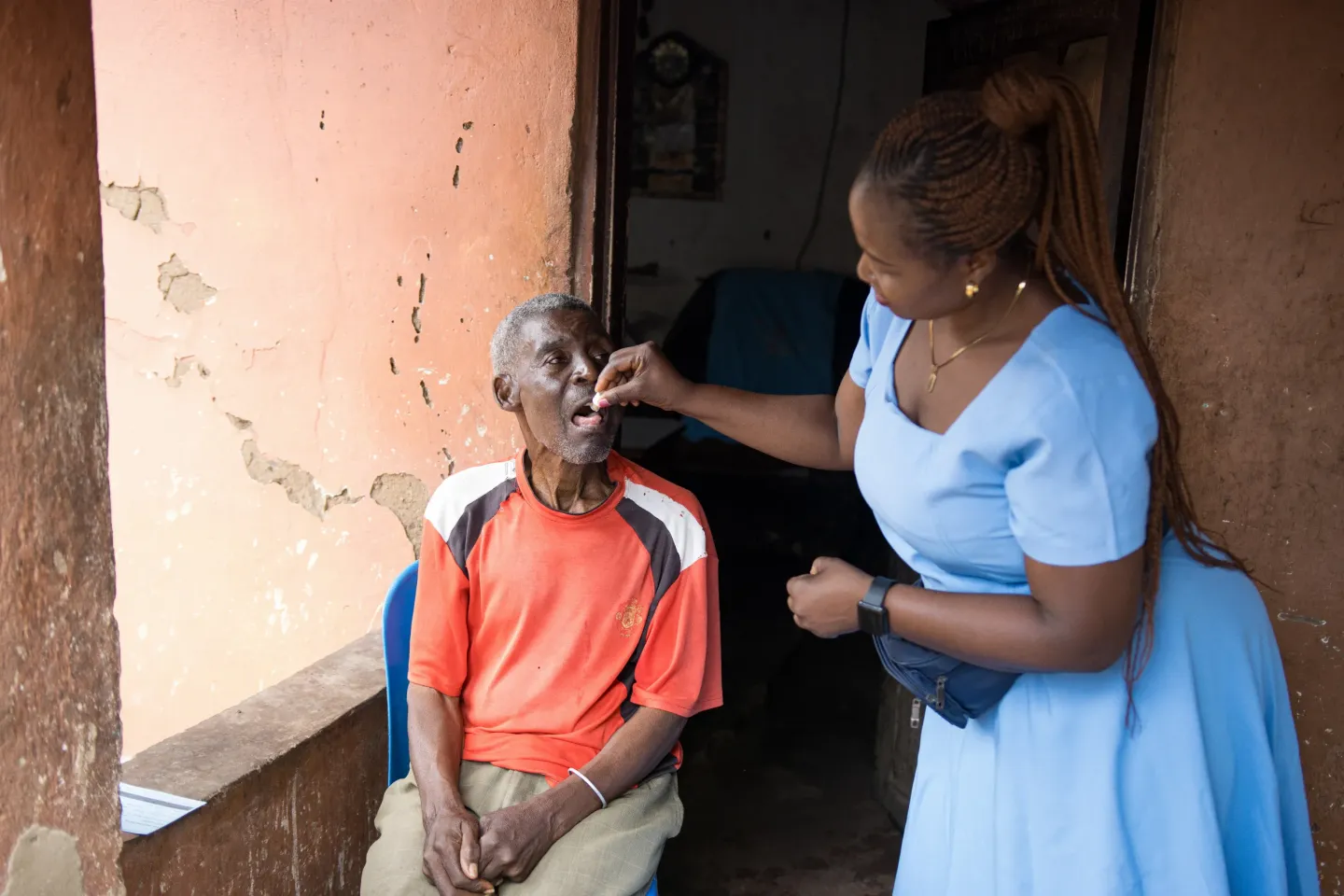 Disease Control Surveillance Assistant, Sellina Zombazomba, in action administering oral cholera vaccine to Lidson Sam, 85-year-old community member in Chilomoni Township, Blantyre District, Southern, during the UNICEF-MOH OCV Campaign. 