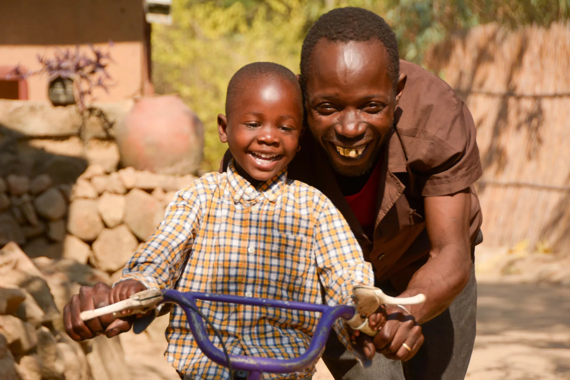 Three year old Lumbani is captured playing with his foster father, 42 year old Luwo Malunga at  their home in Sigerege in the southern city of Blantyr