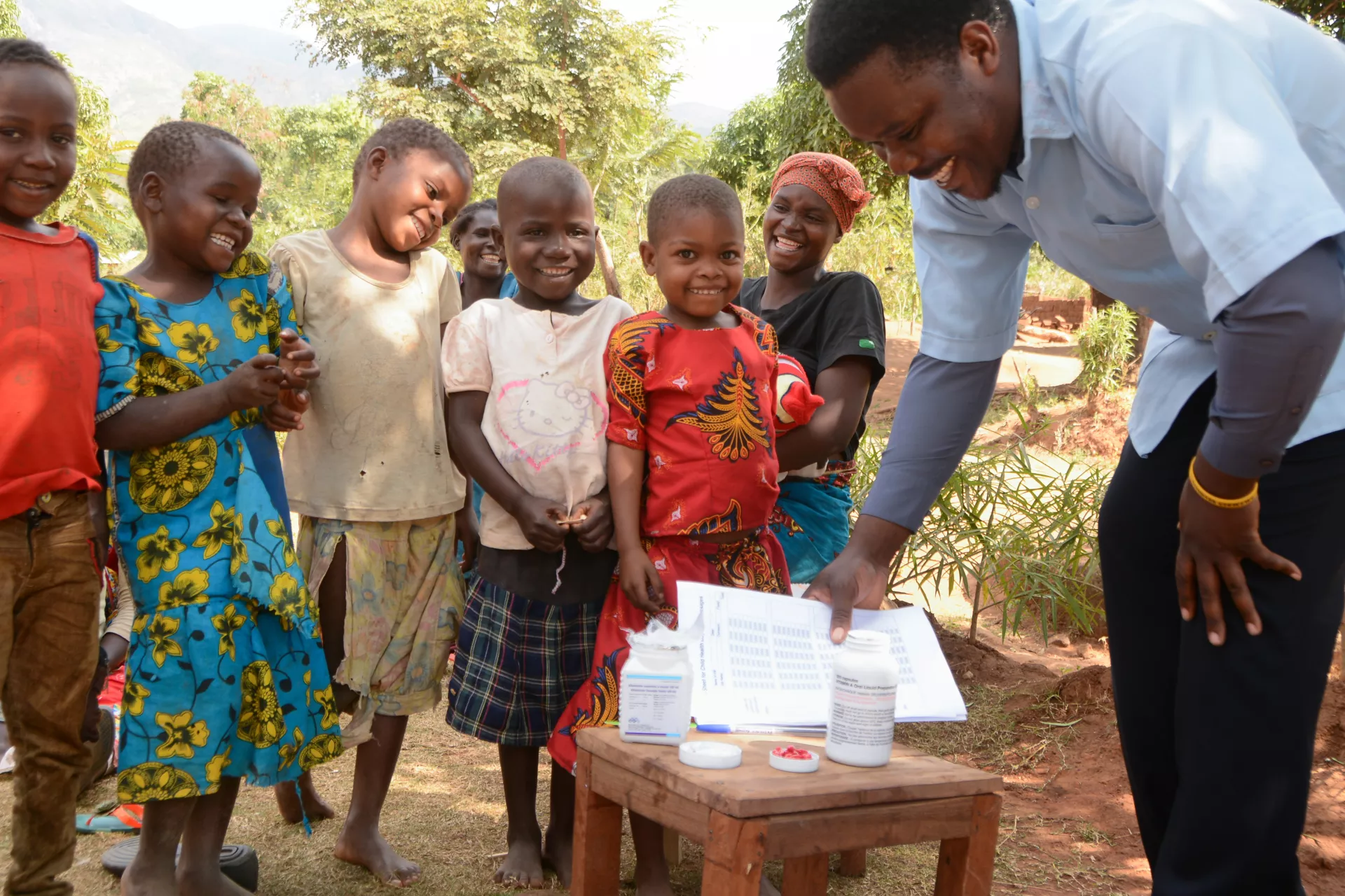 A health officer giving children in Mangumba Village in Zomba,  vitamin A and albendazol during child health days