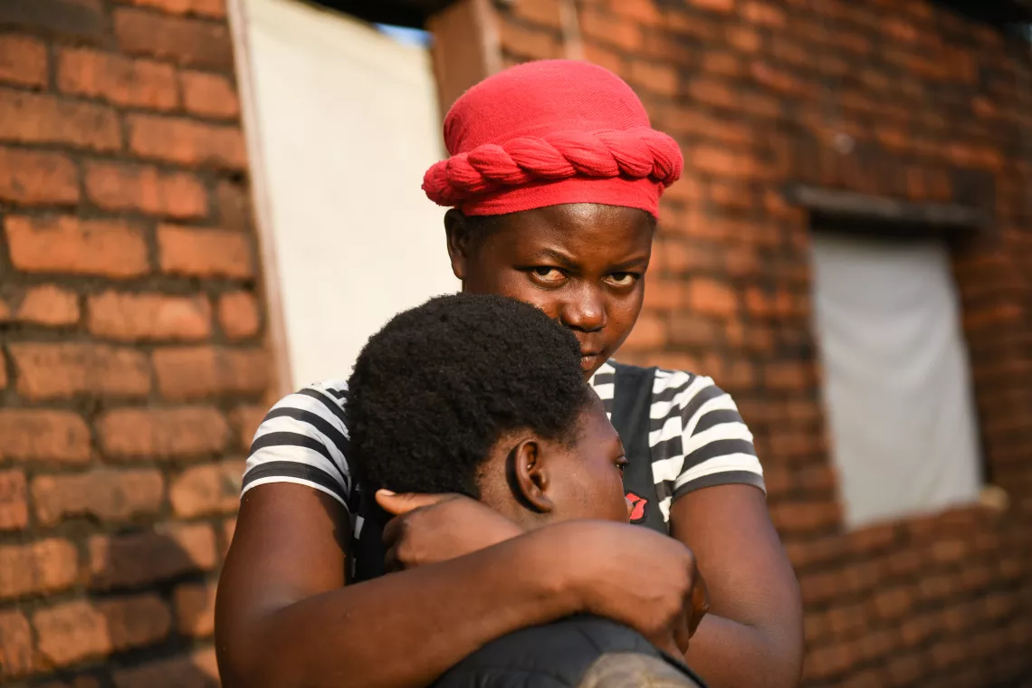 Chimwemwe being held by her Aunt at their home at Pasani Village in Blantyre 