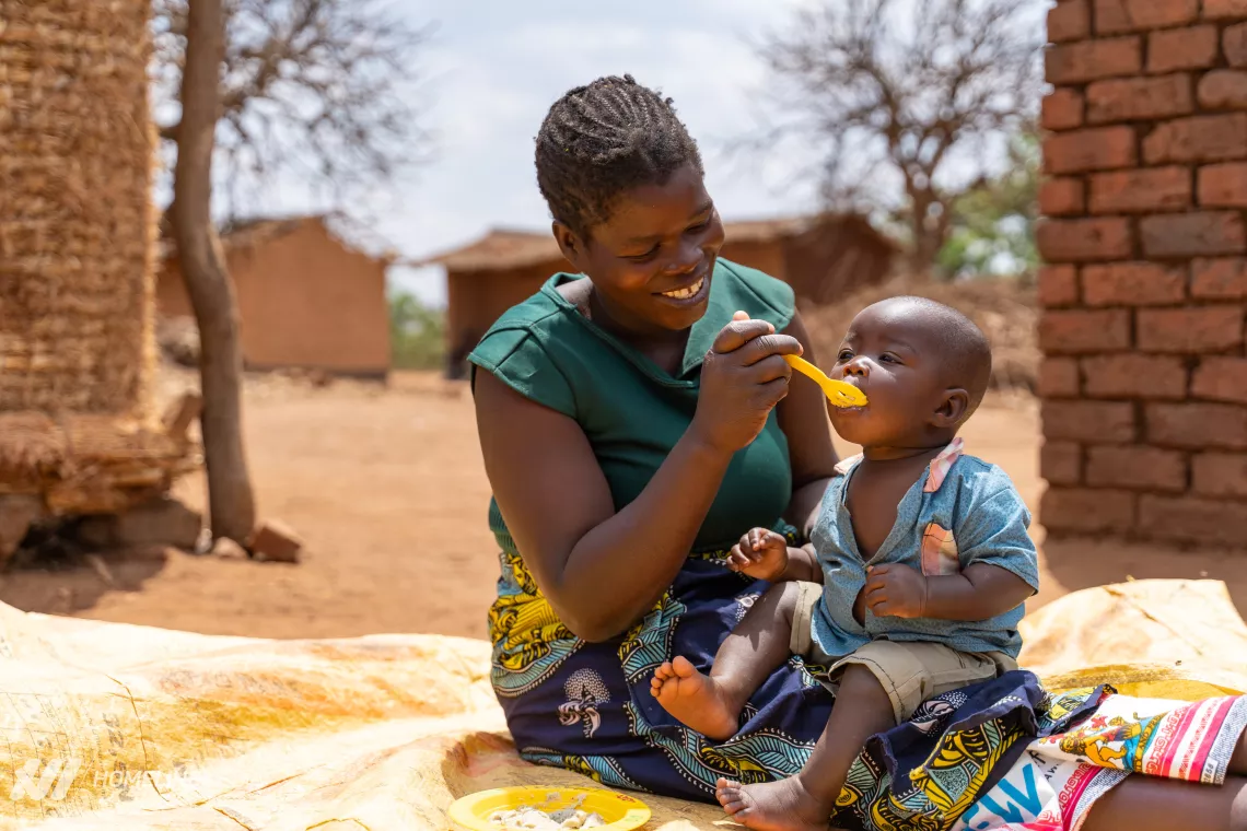A mother feeds her child nutritious porridge in rural Lilongwe