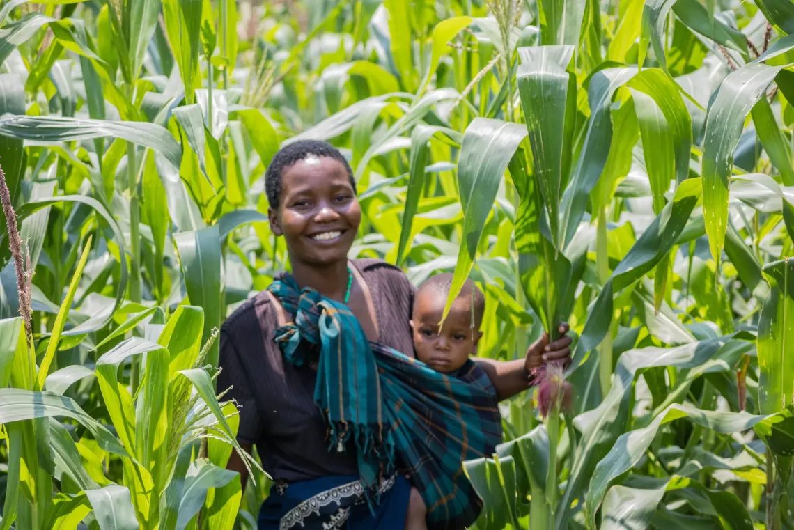 Doreen Thomas and her child tend to crops at their home in TA Kambwiri, Salima, supporting access to diverse foods.