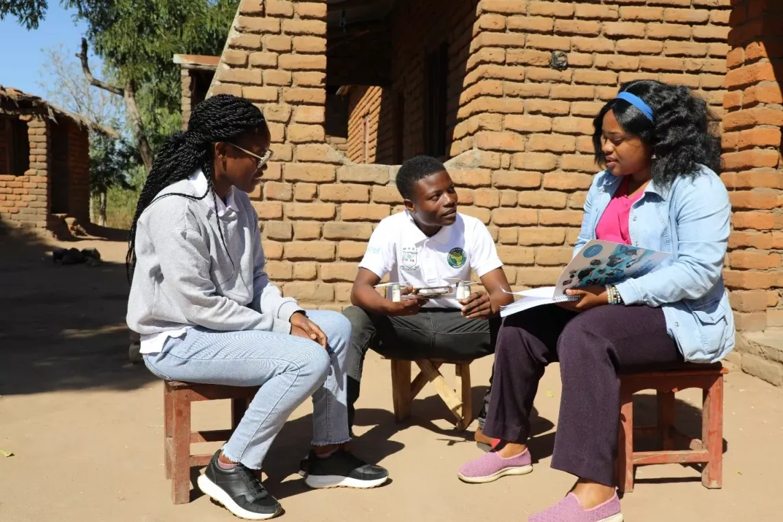 Afick (centre) pictured with his ADDA mentors Kimberly Saka (left) and Rachel Sibale (right) during a monitoring visit in Zomba. &copy;UNICEF/Given Chichitike 