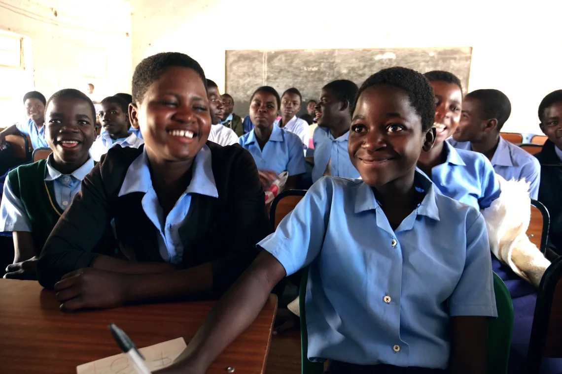 Form 2 students smiles as they follow a lesson in class at Mdeka community secondary school in Blantyre rural
