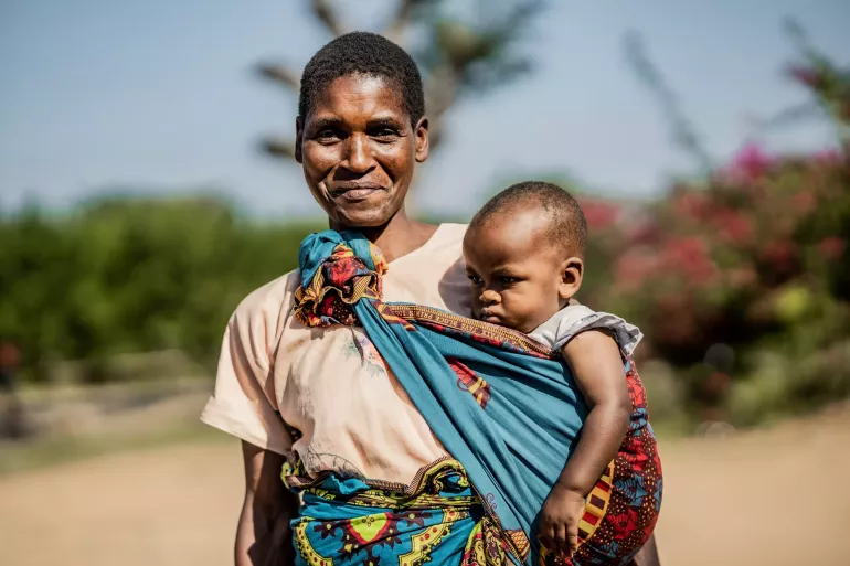 A mother carrying her child with a smile 