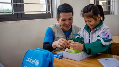 Lang Son, Viet Nam, January 2026. After months of storms and floods disrupted schooling, UNICEF delivered learning kits to help students return to class. Here, a UNICEF education officer shares a joyful moment with a first-grade student &ndash; a reminder that learning can resume, even after crisis.  