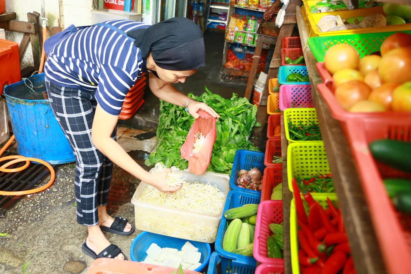 Lady selecting vegetables at sundry shop