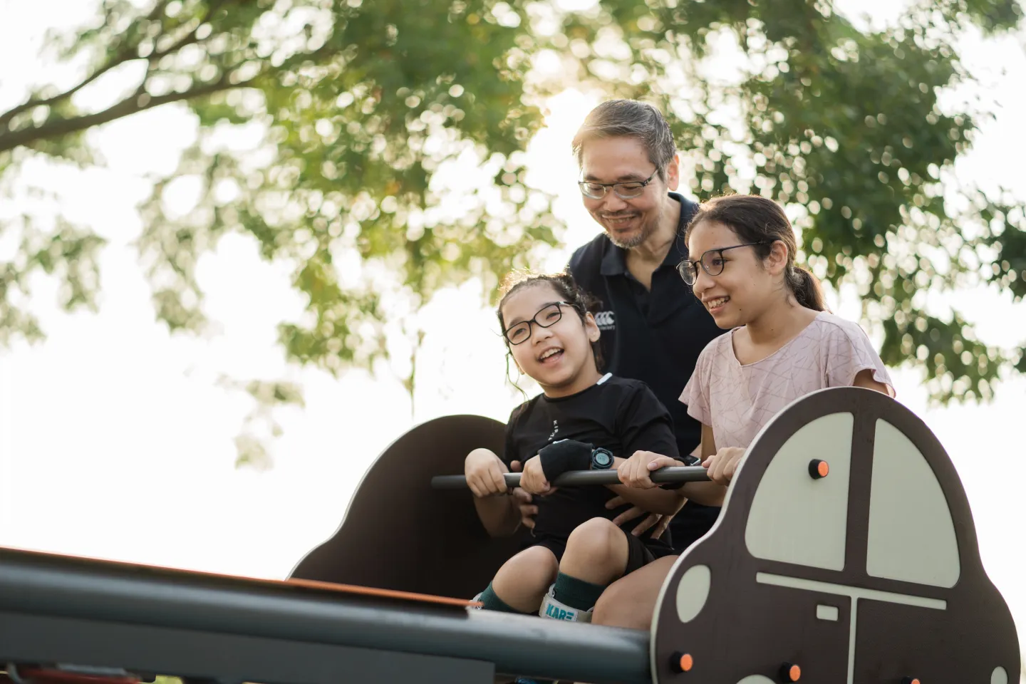 Children & dad playing in playground