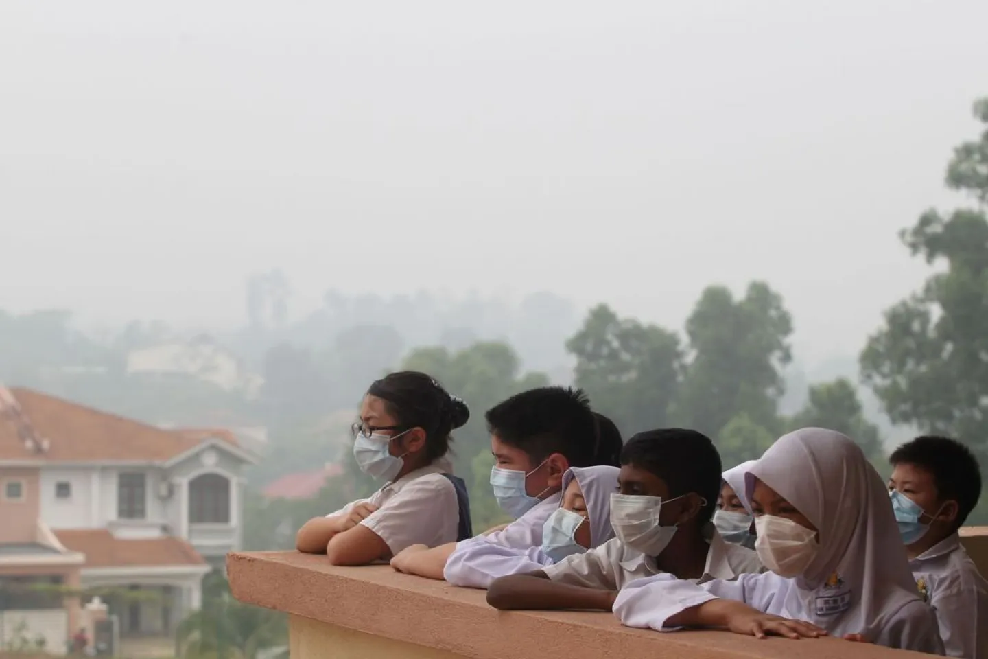 Children wearing masks in a haze-filled balcony