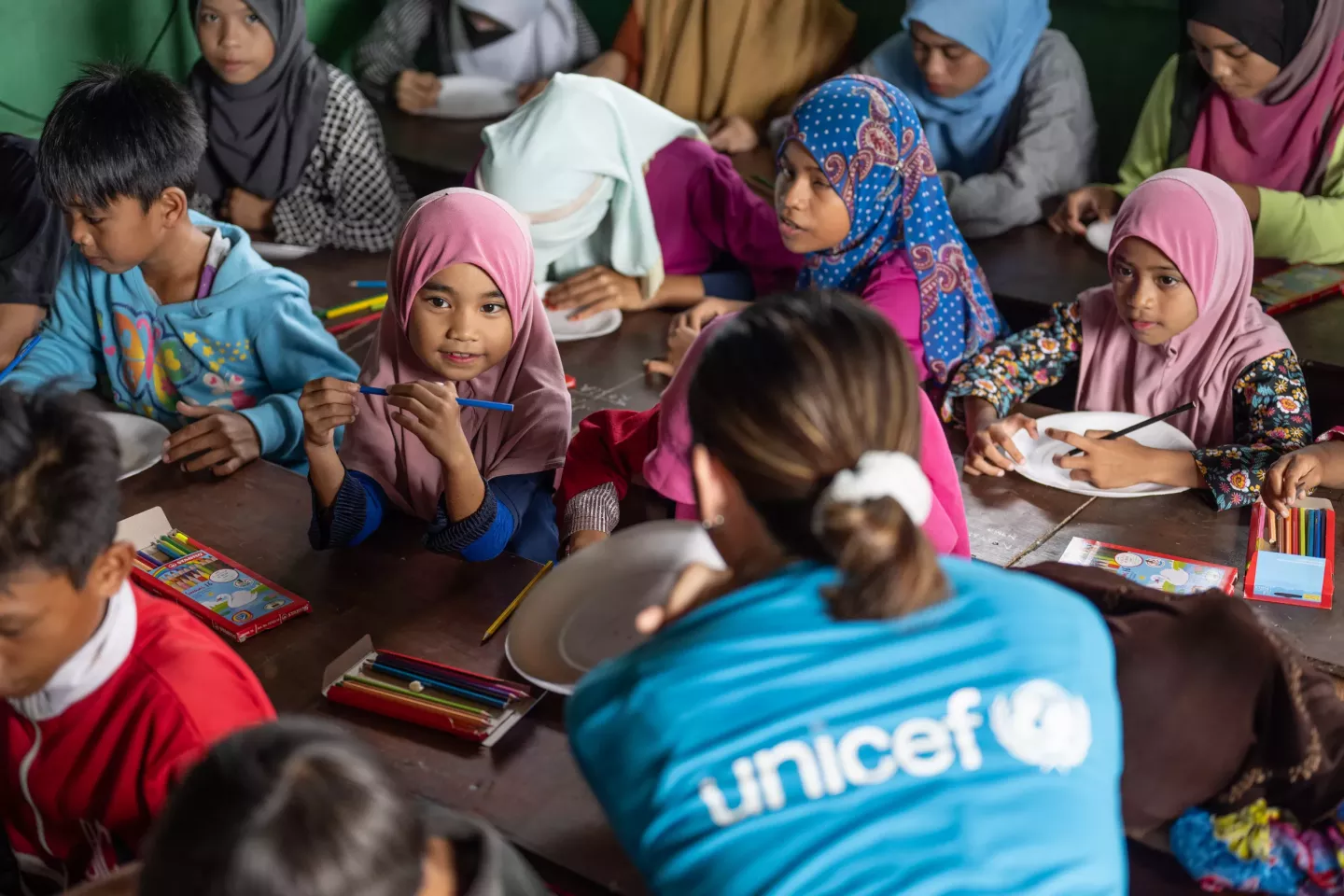 A young girl, Nur, sitting with her classmates in class.