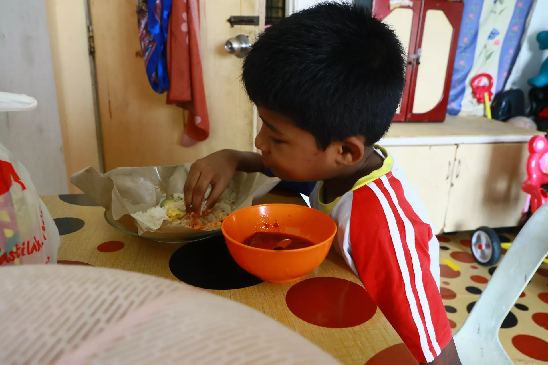 A boy eats his lunch in one of KL's low cost flats