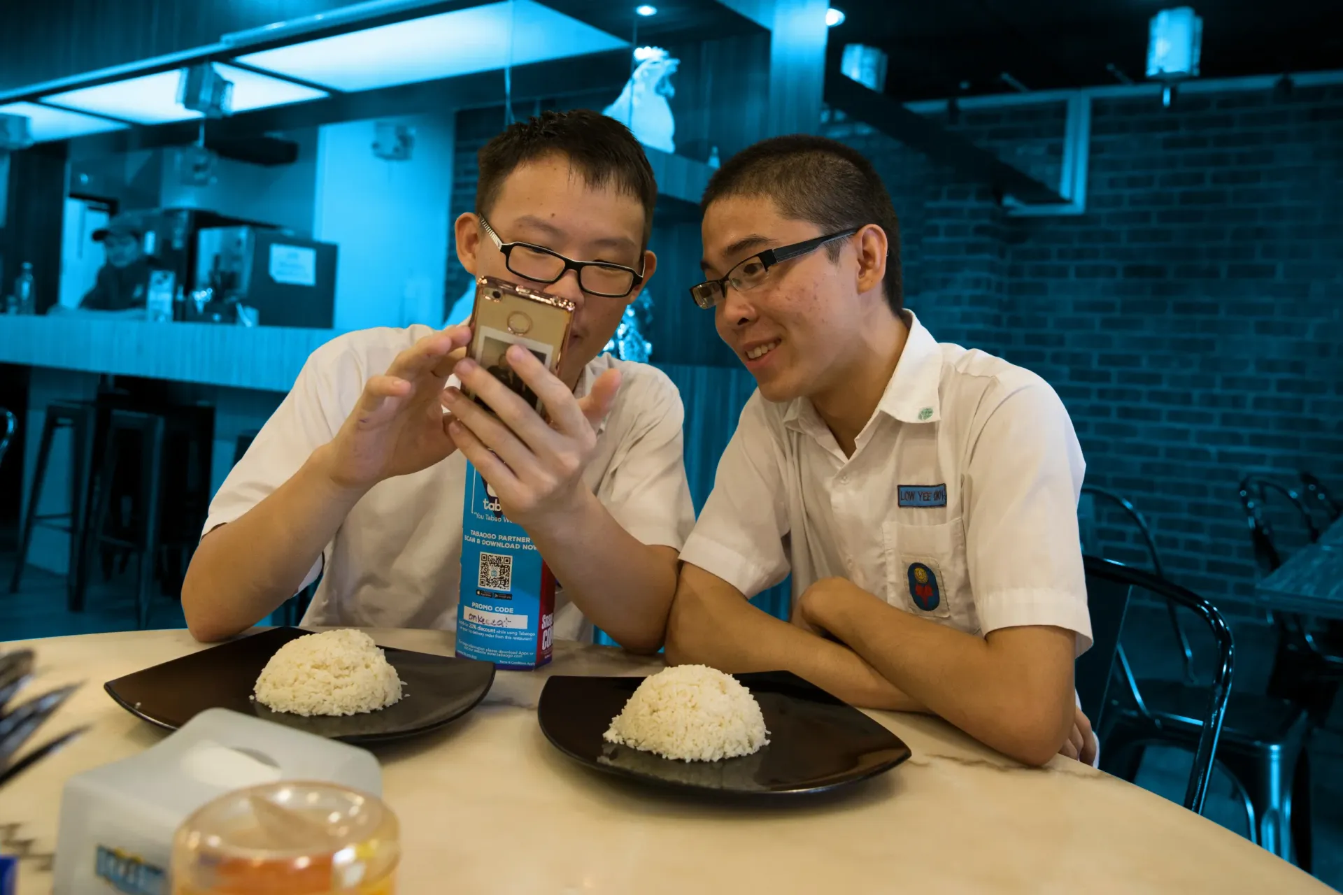 teenagers surfing the web on their phones in school uniform