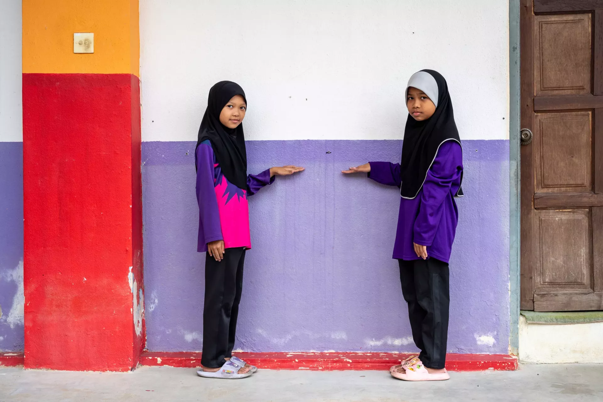 Analia and Dia Umaira, 9 points to the floodwater mark at their school in Rantau Panjang, Kelantan at the east coast of Malaysia. 