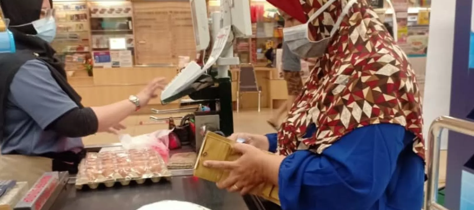 Woman paying for groceries at supermarket