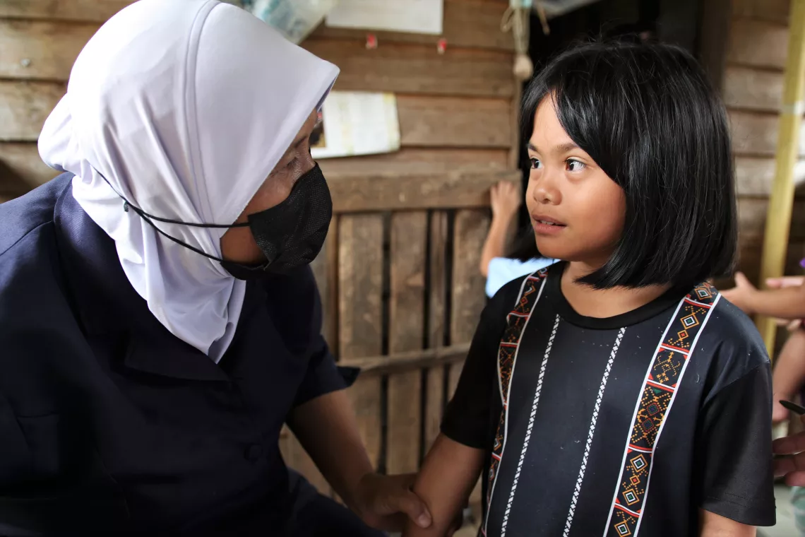 A child talking to a health worker
