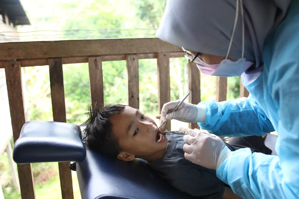 A boy has his teeth examined by a dentist