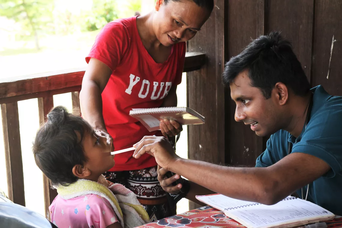 A child checked by doctor while mother looks on