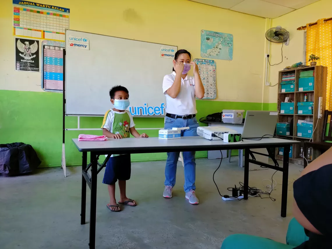Trainer teaches child to wear mask