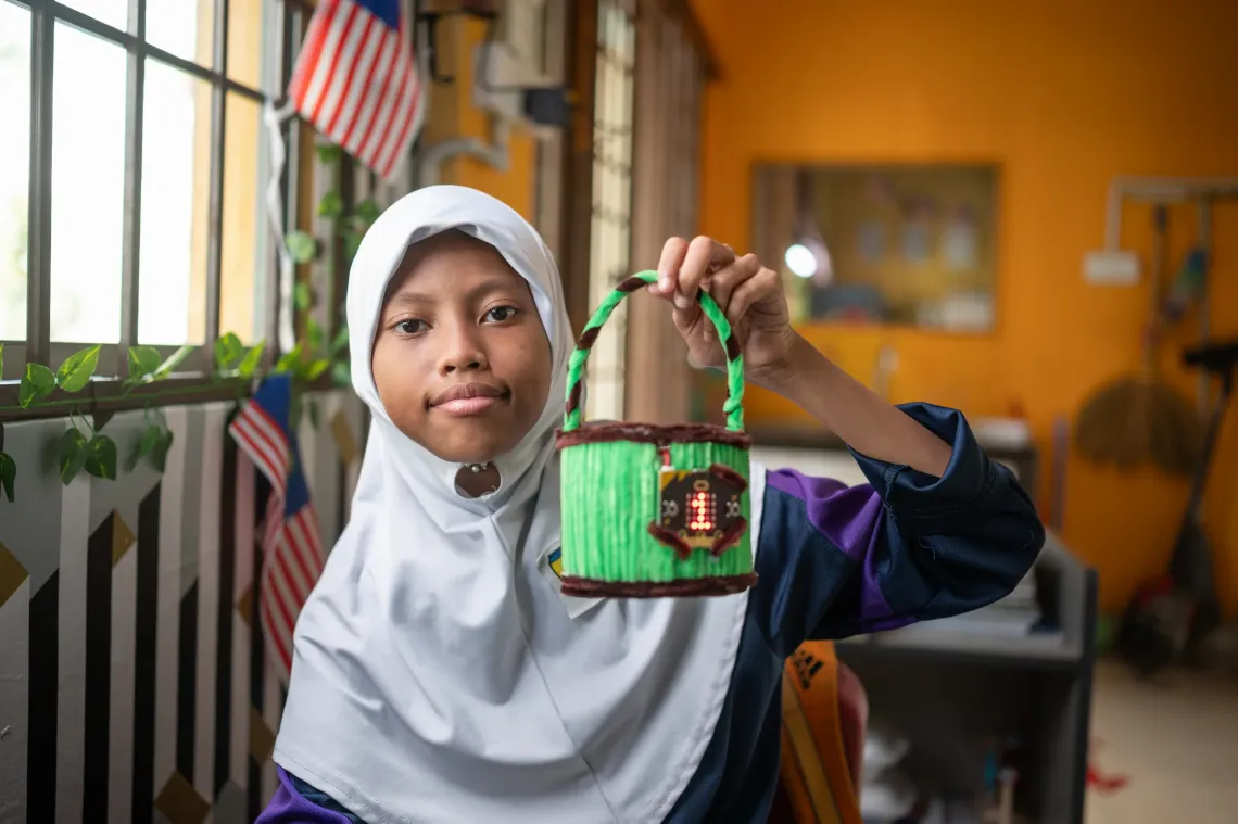 Una holds the &ldquo;Totbin,&rdquo; a hands-on learning tool invented by her teacher using micro:bit technology introduced through Future Skills for All. 