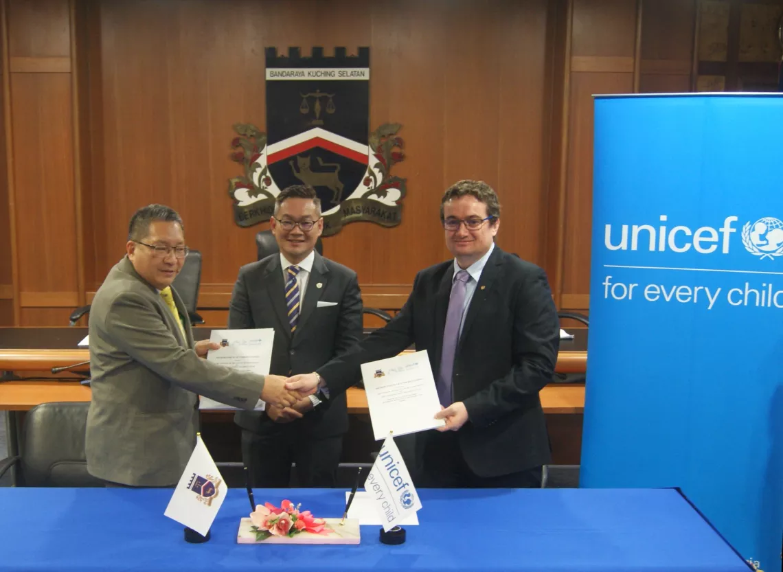 Two men shaking hands while holding document