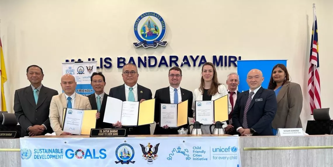 A group of people holding up documents