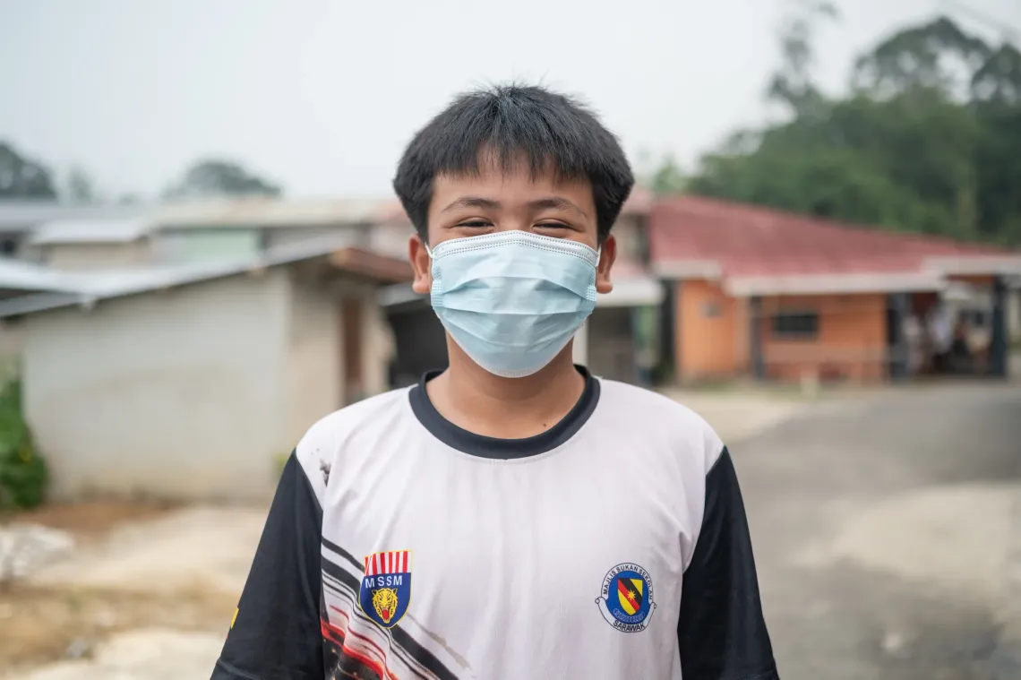 reddy wears a face mask while standing outdoors in his sports jersey in Serian, Sarawak.
