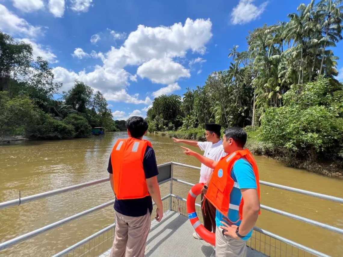 Mercy Malaysia and UNICEF staff on a boat in a river.